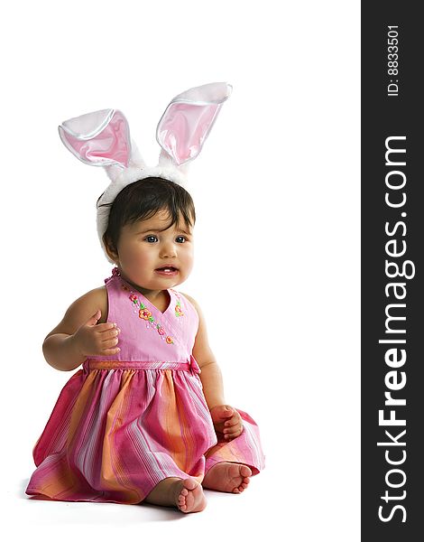 Portrait of a biracial baby girl with a pair of large bunny ears on her head. Isolated on white. Portrait of a biracial baby girl with a pair of large bunny ears on her head. Isolated on white.