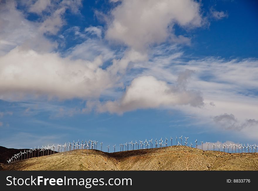 Wind farm on hilltop ridge with blue sky. Wind farm on hilltop ridge with blue sky
