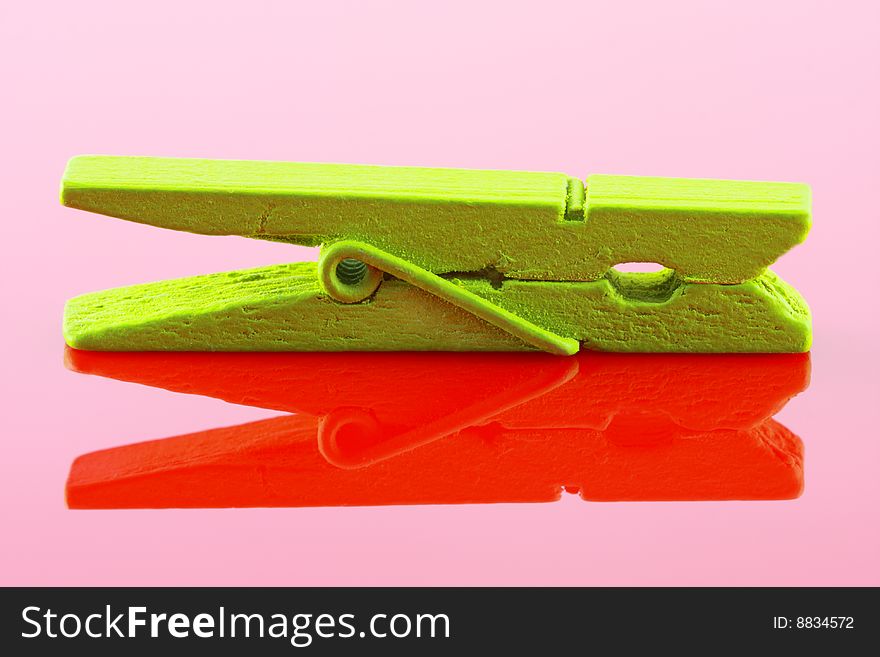 Green wooden clothespin on red