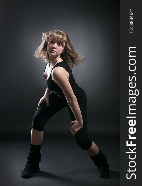 Young woman dancer on black background