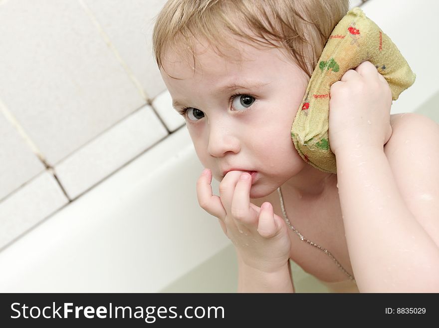 The boy washing his ear in a bathtub. The boy washing his ear in a bathtub