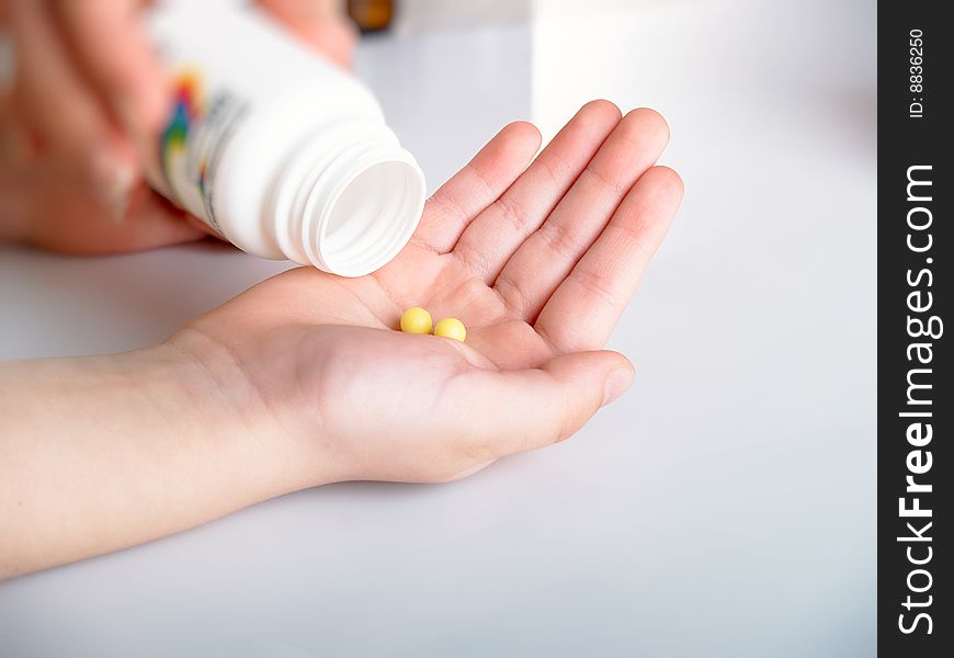 Yellow tablets in a children's hand