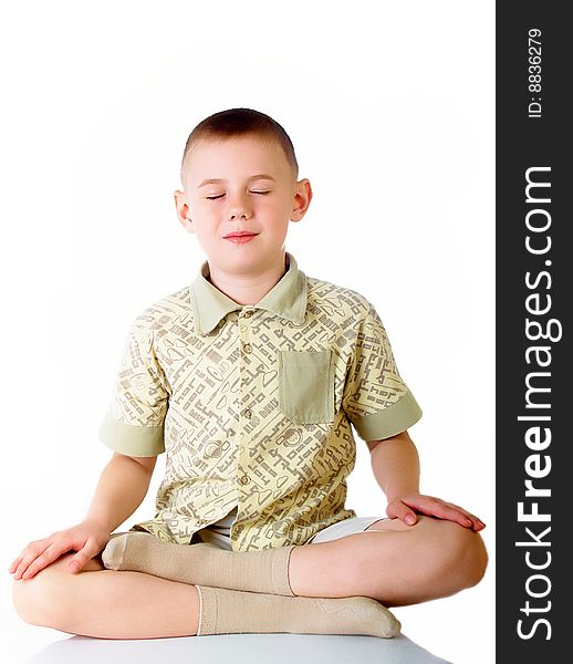The boy sits in a pose of meditation