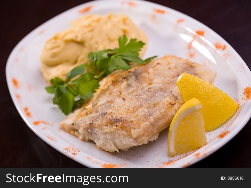 Fried fish and hummus with lemon, selective focus