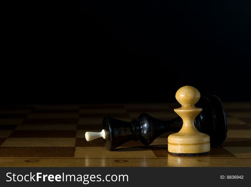 Two chessmen on a chessboard, black background