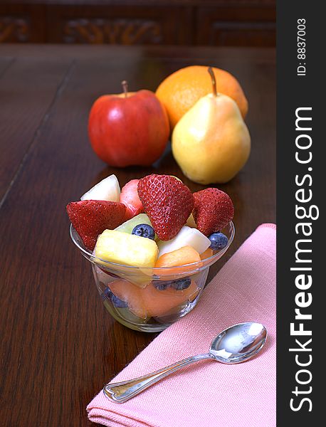 Glass cup overflowing with fresh cut up fruit. Glass cup overflowing with fresh cut up fruit