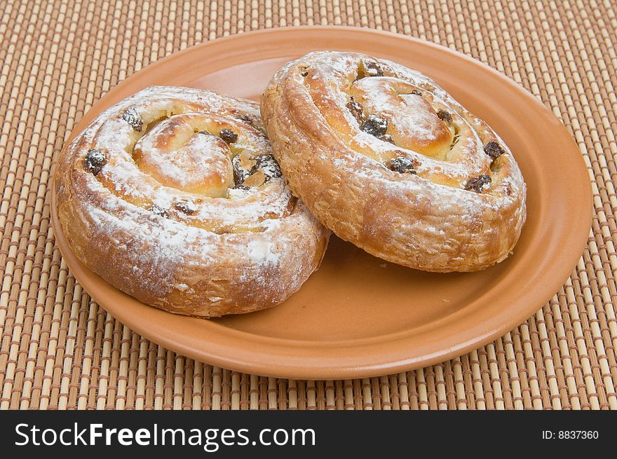 Two sweet buns on a brown plate