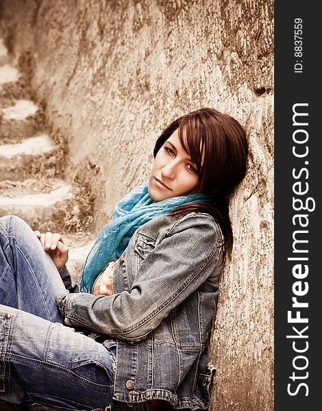Young thoughtful woman sitting on stone stairs. Young thoughtful woman sitting on stone stairs.