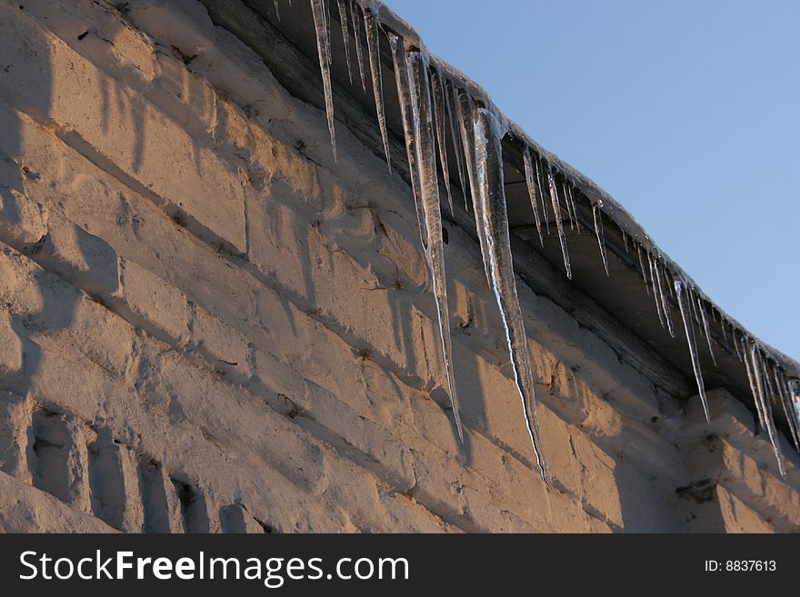 icicles on the roof of brick building