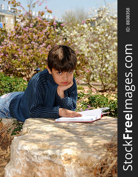 The boy reading the book in park