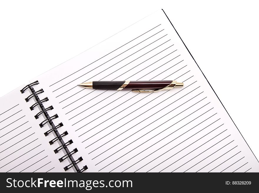 A notebook and a pen on white background. A notebook and a pen on white background.