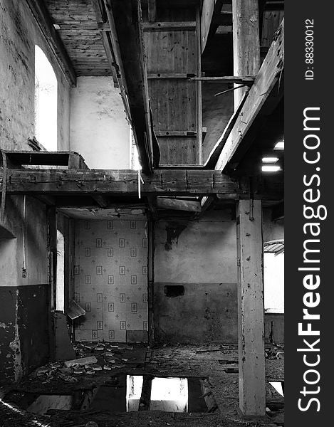 Interior of decaying abandoned building in black and white.