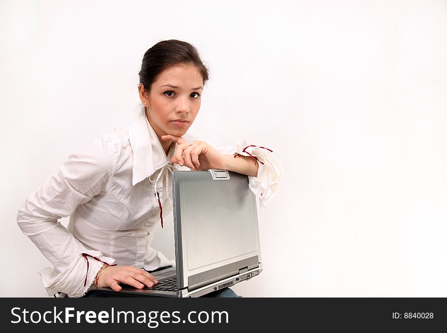 Portrait of beautiful, thoughtful,   sitting  girl in a white blouse  holding a notebook on knees, on a white background. Portrait of beautiful, thoughtful,   sitting  girl in a white blouse  holding a notebook on knees, on a white background