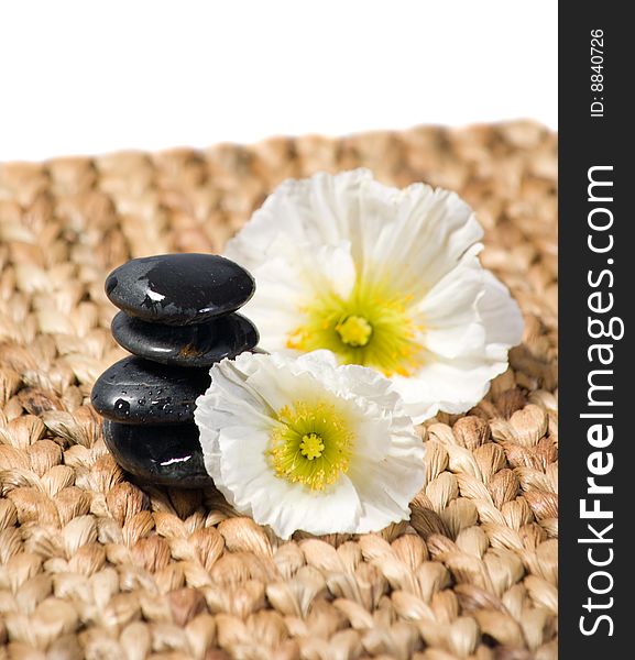 Zen stones with white flowers on a grass matte