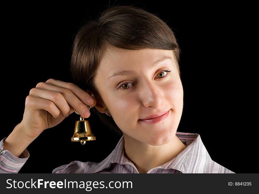 Young woman ringing a golden bell on black background. Young woman ringing a golden bell on black background