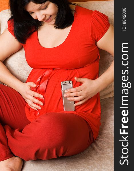 Young pregnant woman with mobile phone