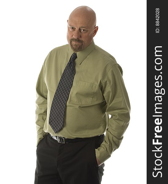 baldheaded businessman dressed in green shirt grey tie with hands in pockets of black pants. baldheaded businessman dressed in green shirt grey tie with hands in pockets of black pants