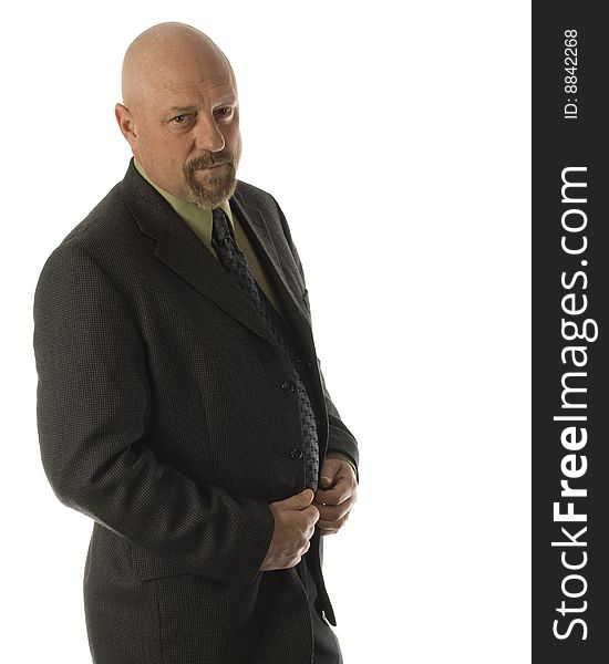 Caucasian bald businessman dressed in a green shirt with grey tie and black pants with both hands on jacket looking serious. Caucasian bald businessman dressed in a green shirt with grey tie and black pants with both hands on jacket looking serious