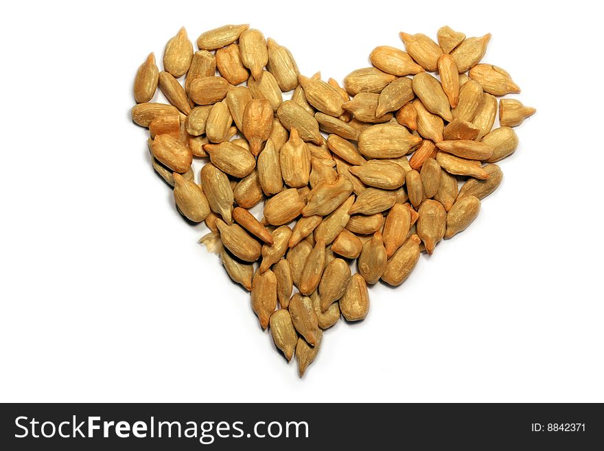 Sunflower seeds in the shape of a heart on white background. Sunflower seeds in the shape of a heart on white background.