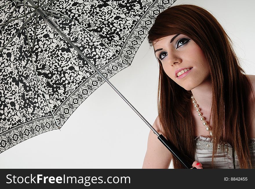 Female model standing under an pen umbrella. A studio landscape shot. Female model standing under an pen umbrella. A studio landscape shot.