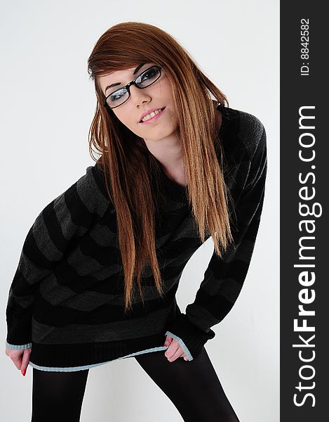 Female fashion model wearing reading glasses and casual clothing. standing against a white back drop. Female fashion model wearing reading glasses and casual clothing. standing against a white back drop.