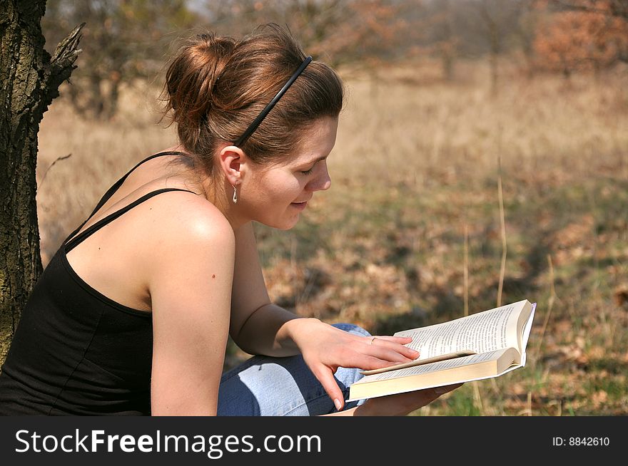 Young girl reading a book outdoor