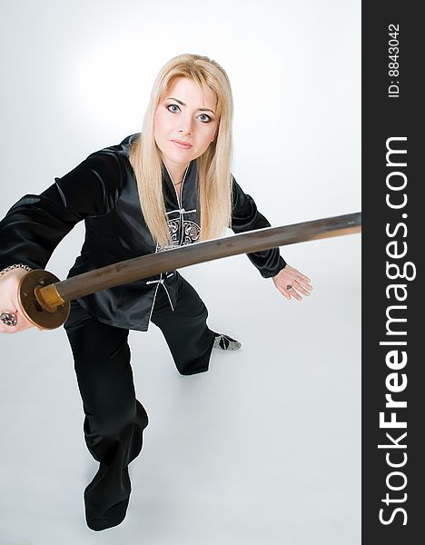 Woman in Japanese shirt with sword, studio shot