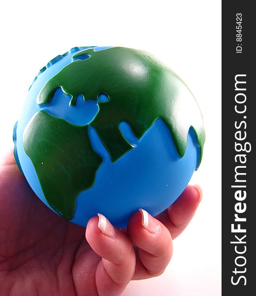 A woman's hand holding a plastic globe. A woman's hand holding a plastic globe