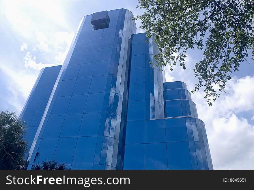 Modern blue office building vertical perspective and sky reflecting off the windows