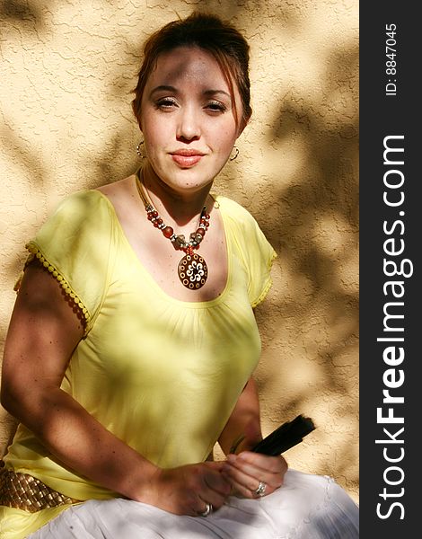 Beautiful Spanish woman with yellow blouse holds her traditional fan ready to snap you if you displease her. Beautiful Spanish woman with yellow blouse holds her traditional fan ready to snap you if you displease her.
