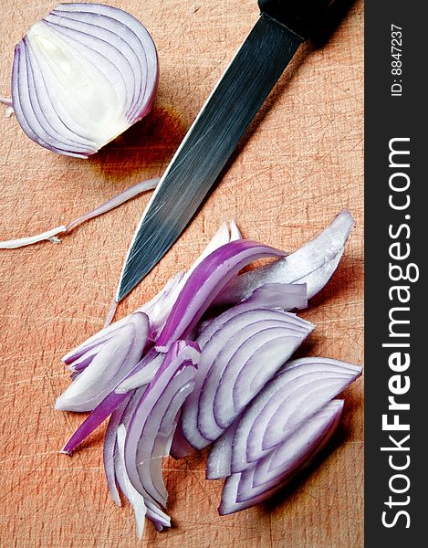 Red onion and a knife on cutting board