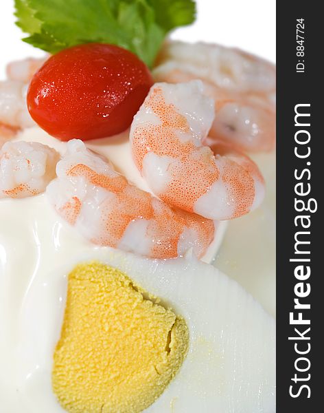 Detail of egg and shrimp sandwich with mayonnaise and a cherry tomato. Top of the photo isolated on white. Shallow depth of field with the shrimps in focus.