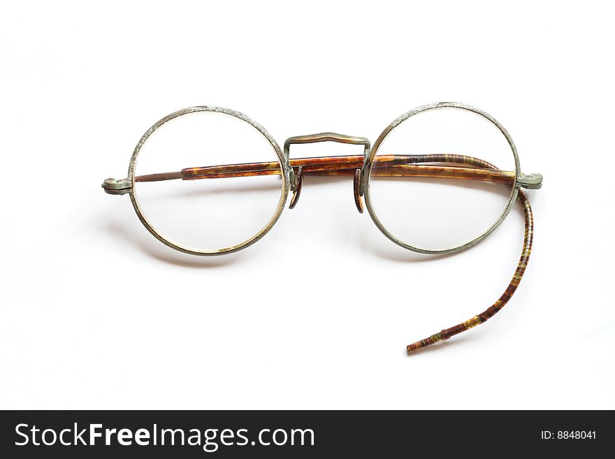 Old spectacles without one side lying on white background