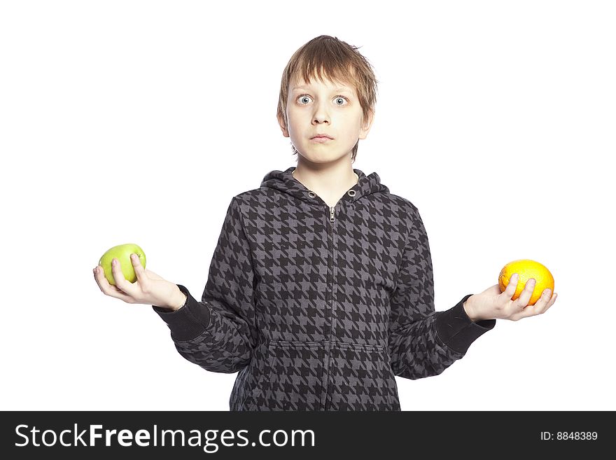 Isolated boy holding apple and orange over white background