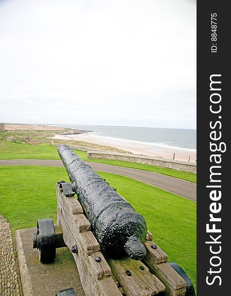 A cannon on the walls of bamburgh castle in england. A cannon on the walls of bamburgh castle in england