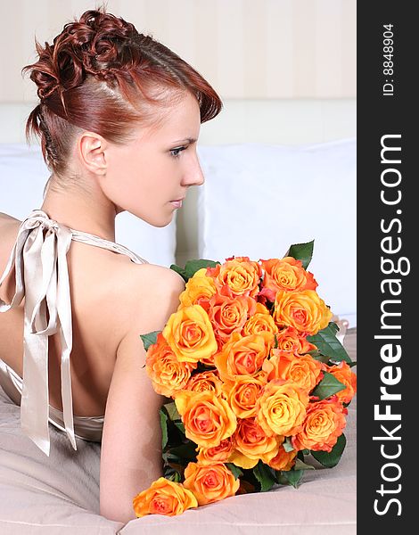 Beautiful young woman with bunch of roses