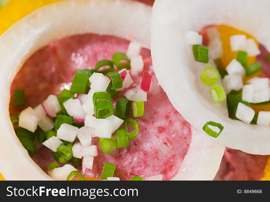 Close-up of Danish style salami sandwich with onion rings, yellow bell pepper and chives. Close-up of Danish style salami sandwich with onion rings, yellow bell pepper and chives.