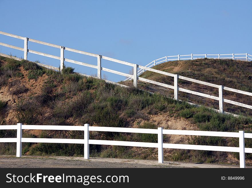 Intersecting white wooden fences on the hill side. Intersecting white wooden fences on the hill side