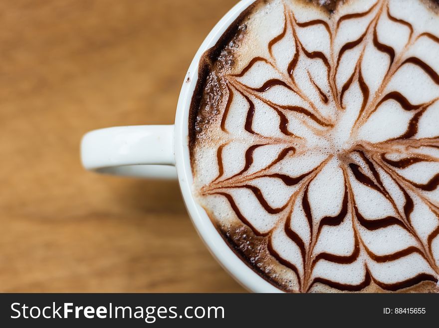 Overhead view of cup of cappuccino with artistic chocolate design. Overhead view of cup of cappuccino with artistic chocolate design.