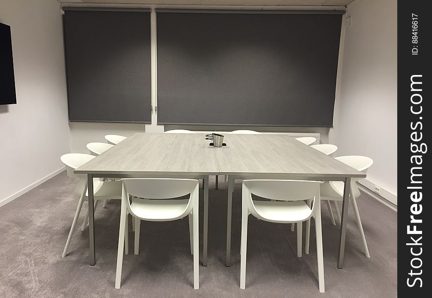 A modern meeting room with table and chairs in the middle.