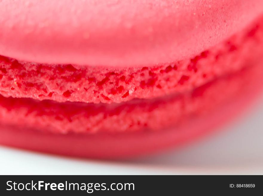 A close up of a red macaron cookie.