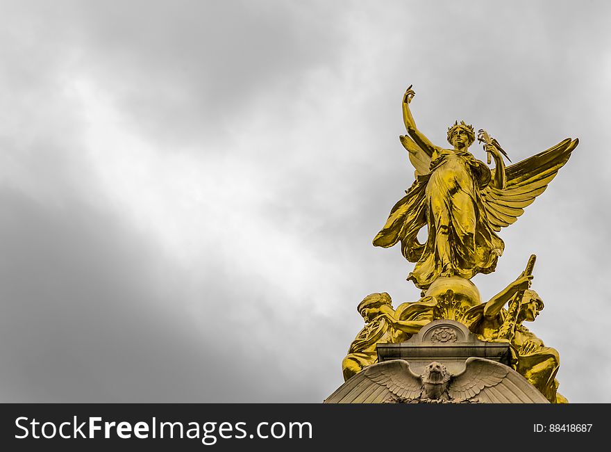 Gold Angel Statue Under Grey Clouds