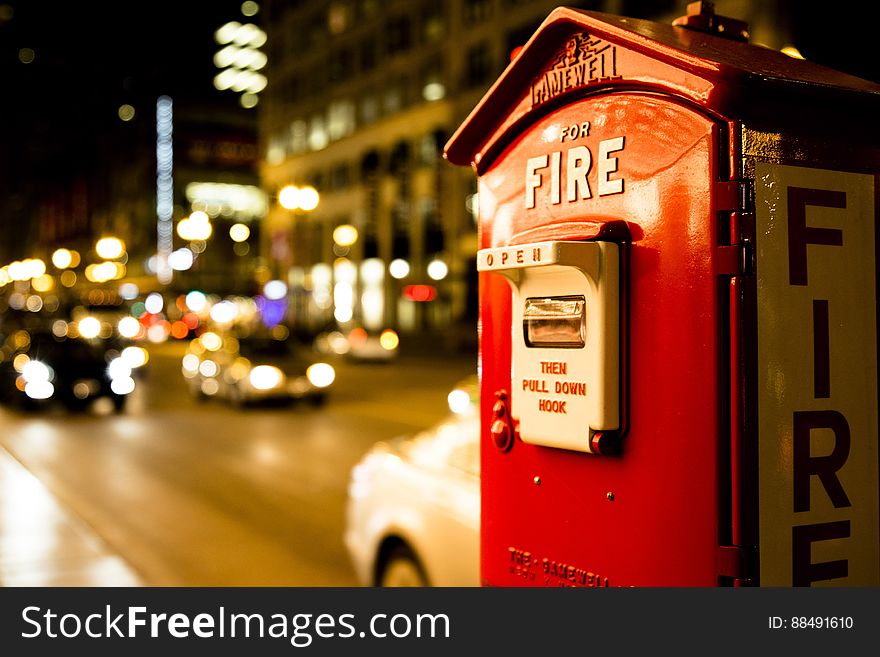 A vintage fire box in the city at night.