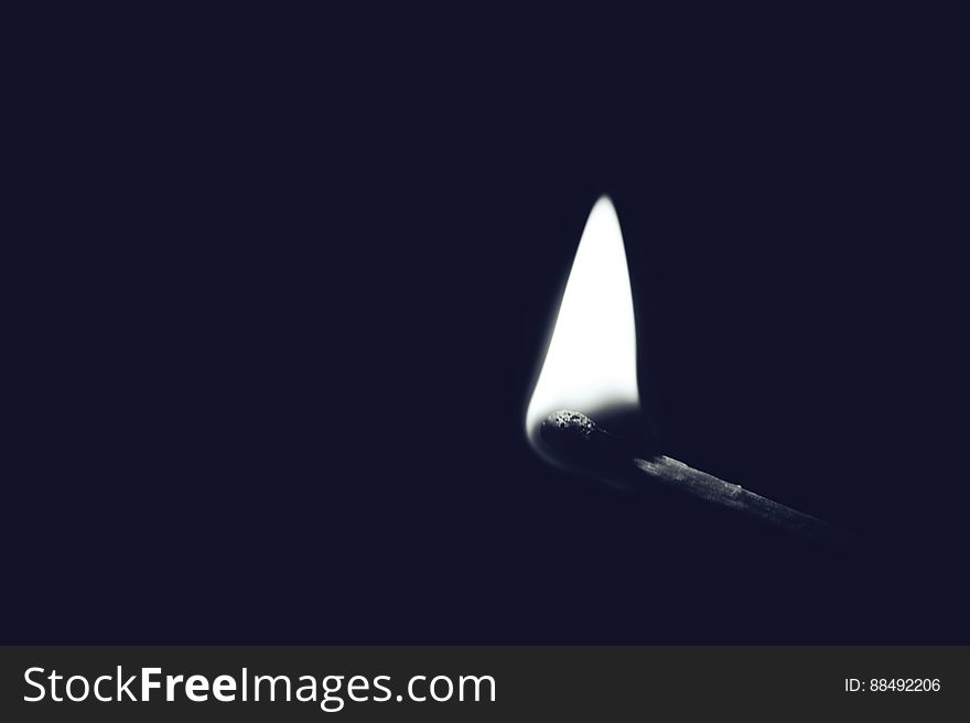 Head of freshly lighted match with dark background and copy space.