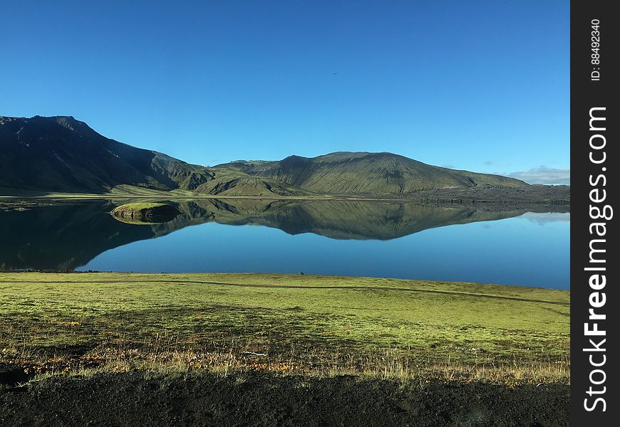 A lake and mountains reflecting on its surface.