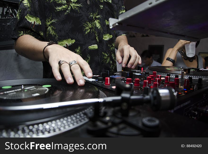 A close up of dj`s hands on a mixer at a party. A close up of dj`s hands on a mixer at a party.
