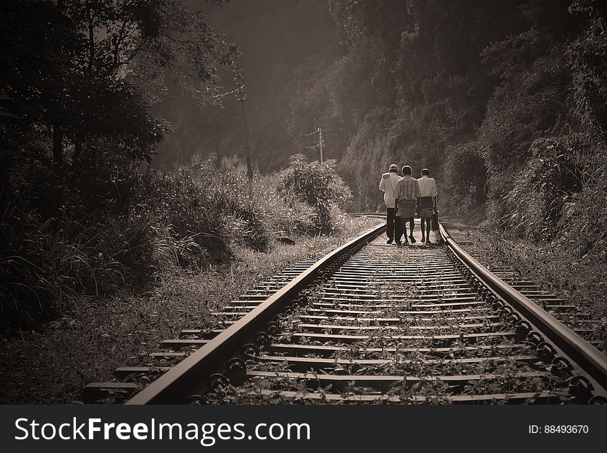 People Walking on Railroad Tracks