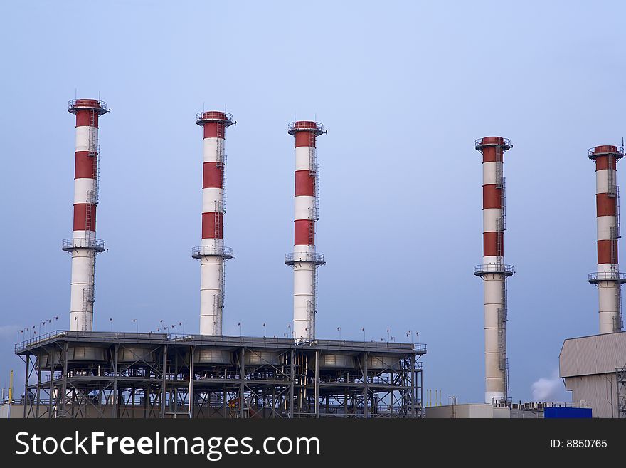 With smoke stacks against a blue sky. With smoke stacks against a blue sky