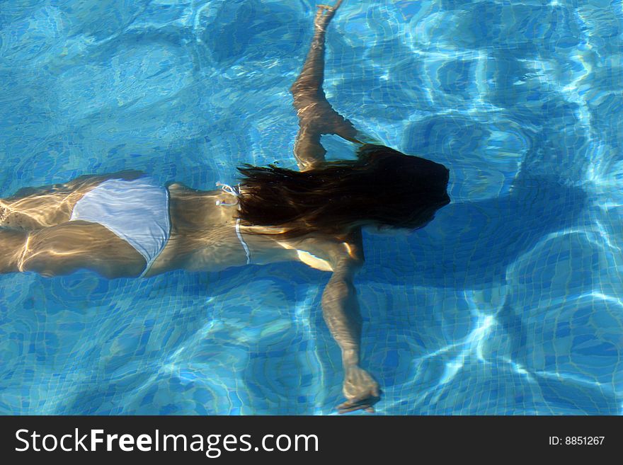 Woman in bikinis diving in the swimming pool. Woman in bikinis diving in the swimming pool
