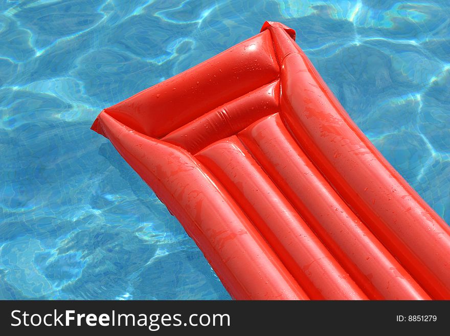 Orange air mattress in the swimming pool. Orange air mattress in the swimming pool